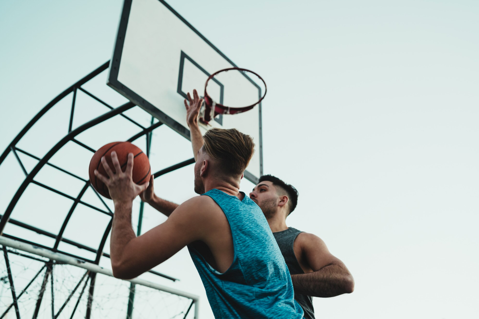 Deux hommes qui jouent au basketball près du panier