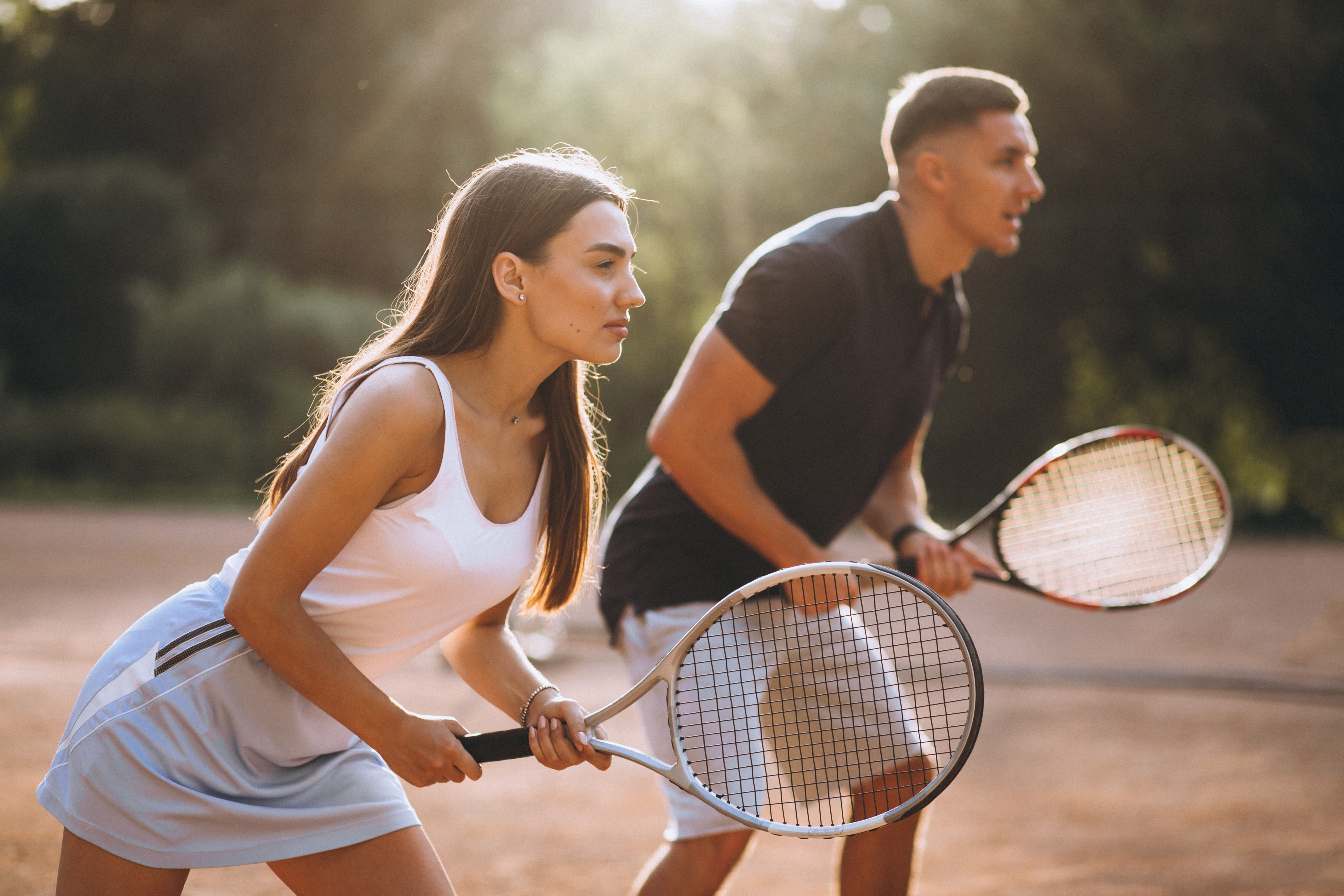 Un homme et une femme qui jouent au tennis